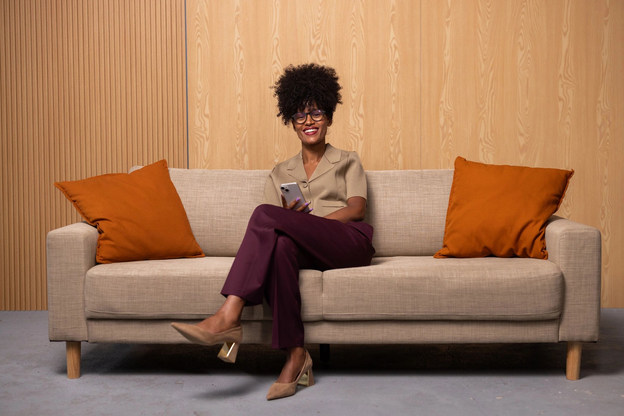 Woman seated on a couch using a phone